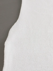 Detailed macro view of white knitted fabric texture on minimalist sleeveless sweater top