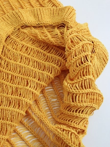 Detailed close-up of bright yellow crochet knit texture and ribbed hem on a summer dress