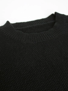 Detailed view of the ribbed crew neck and fine knit texture of a black slim sweater