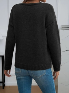 Detailed view of dark grey knit sweater showing ribbed cuffs and soft texture