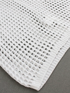 Detail view of white knitted mesh fabric texture with 100% polyester rib edge