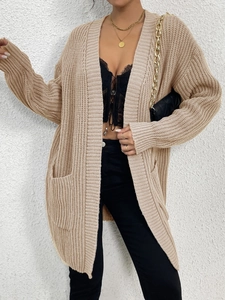Close-up of beige knit cardigan texture and large front pockets for a stylish winter look