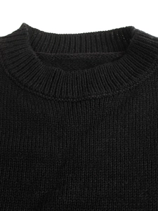 Close-up of the ribbed crew neck and high-density knit texture of this black sweater