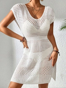 White knit crochet mini dress featuring a V-neck, sleeveless design, and geometric patterns