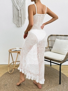 Detail of white crochet knit maxi dress featuring a hollow-out mesh design and wavy hem
