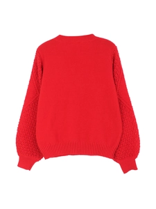 Detail of red knit sweater featuring intricate hollow crochet patterns on the long sleeves