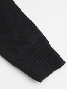 Detailed view of the ribbed knit cuffs on a black crewneck sweater with refined texture