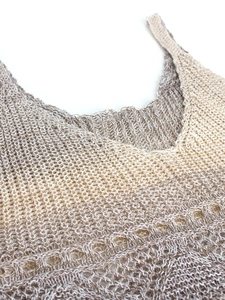 Détail du débardeur de plage en maille montrant la texture ajourée et le dégradé beige
