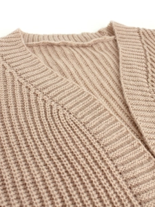 Detailed macro view of the ribbed knit neckline on this beige long-sleeve cardigan