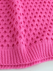 Macro della trama in maglia all'uncinetto rosa con dettaglio bordo a coste