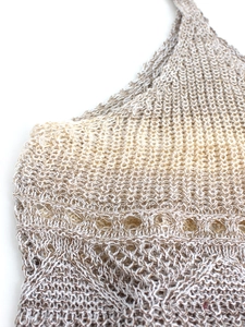Gros plan détaillé montrant la texture du crochet ajouré sur ce crop top de plage beige