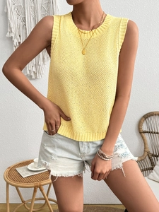 Detail of a bright yellow knit sleeveless top featuring a ribbed crew neck and hem