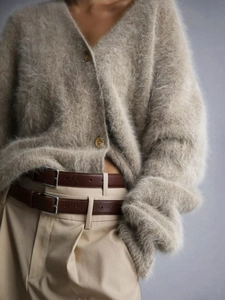 Detail of soft beige mohair cardigan showing V-neckline and round button textures