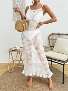 Close-up of white knit crochet beach maxi dress featuring hollow out details and ruffled hem