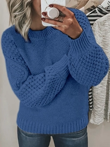 Detail shot of blue chunky cable knit sweater featuring round neck and balloon sleeves