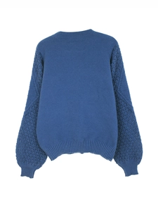 Detail view of navy blue knit sweater featuring intricate hollow lace crochet sleeve design