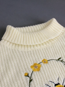 Pull à col roulé crème pour femme avec broderies florales élégantes et détails tricotés