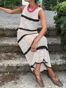 Detail of white crochet knit dress with black stripes and hollow out floral texture