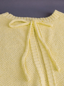 Yellow knit halter top with bow neckline featuring textured waffle pattern detail