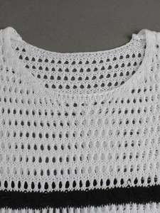 Detailed close-up of white crochet knit hollow-out top with black and white stripes
