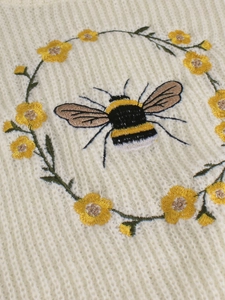 Pull beige à col roulé avec broderies détaillées d'abeilles et de fleurs jaunes