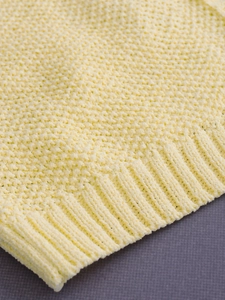Women's crewneck knit vest in soft cream yellow featuring pineapple stitch and ribbed hem