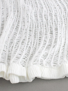 Detail of white laddered knit fabric showing breathable hollow texture and ribbed hem