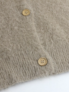 Close-up of oatmeal knit cardigan featuring plush texture and round wooden buttons