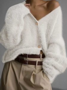 Close-up of white fluffy knit cardigan featuring a V-neck design and round buttons