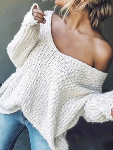 Detalle de jersey de punto grueso blanco con cuello de pico y hombros caídos