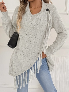 Dettaglio del maglione grigio in maglia con orlo asimmetrico e frange con bottone grande