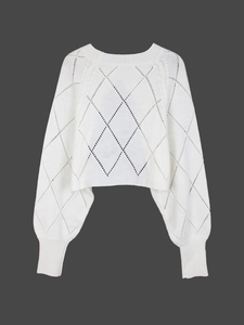 Detail of white cropped knit sweater featuring intricate diamond hollow patterns and cuffs