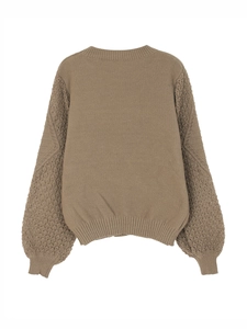 Detail of camel knit sweater featuring intricate hollow crochet lace on drop-shoulder sleeves