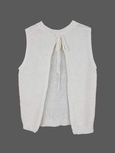 Detail of white knit vest showing backless design with tie-up closure and soft texture