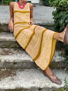 Detailed close-up of knit crochet maxi dress featuring contrast stripes and hollow texture