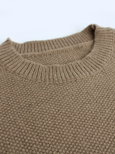 Detailed close-up of brown crew neck knit sweater showing thick ribbed collar and waffle texture