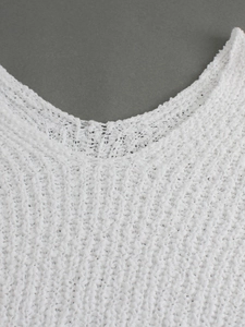 Detalle del cuello del suéter de punto blanco mostrando la textura gruesa y el tejido