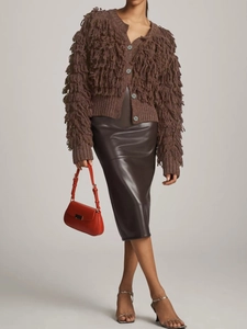 Close-up of brown knitted cardigan featuring long fringe tassels and button-down front detail