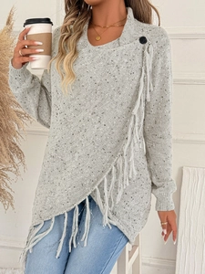 Dettaglio di maglione grigio in maglia con frange e design asimmetrico a portafoglio
