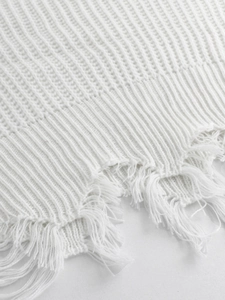 White V-neck off-shoulder knit sweater with ribbed texture and distressed tassel hemline