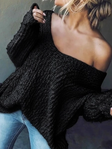 Detalle del suéter de punto negro con cuello en V calado y diseño de hombros descubiertos