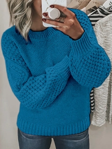 Detail of cable knit and honeycomb texture on blue crewneck long sleeve sweater