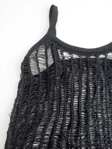Detail view of the black knit cutout texture and layered ladder weaving on the long dress