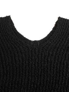 Detalle del cuello en V de un suéter de punto negro con textura gruesa y diseño calado