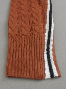 Rust orange turtleneck knit sweater with classic cable knit and side stripe detail