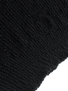 Detalle de jersey negro con cuello en V que muestra la textura de punto grueso y los canalés