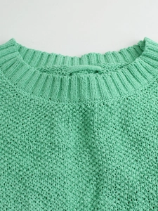 Detailed macro shot of mint green chunky knit texture and ribbed crew neck design