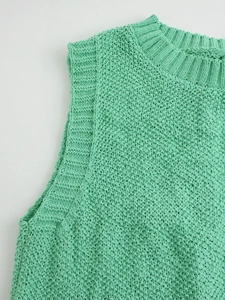 Detailed view of mint green knit vest featuring honeycomb texture and ribbed neckline