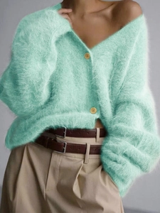 Detail view of mint green plush knit cardigan featuring V-neck and yellow buttons
