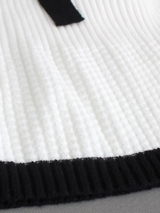 Women square neck sweater featuring cream knit texture and black ribbed hem with bow detail